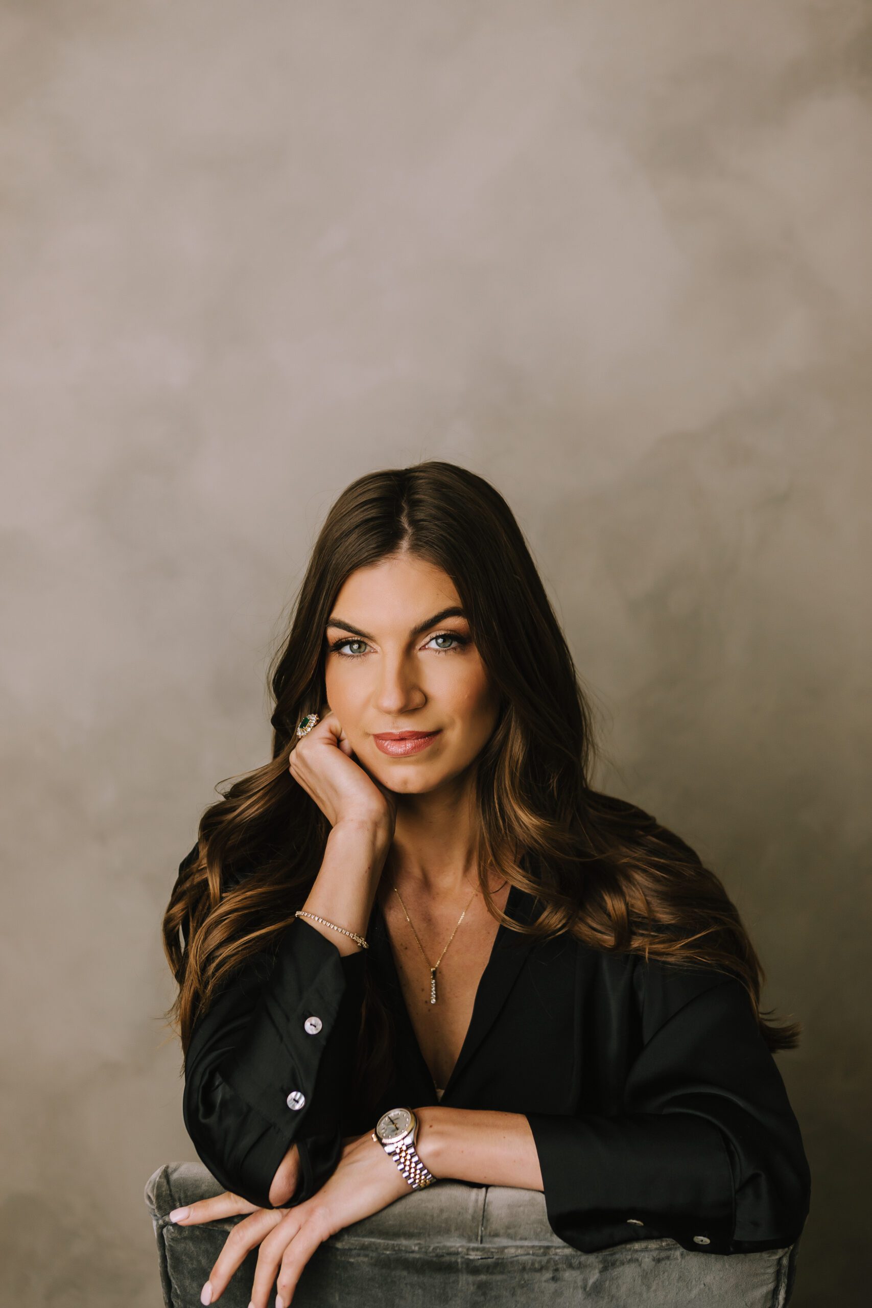 Close-up professional headshot of woman with dark hair against neutral backdrop during personal branding session in Doylestown PA by SugaShoc Photography